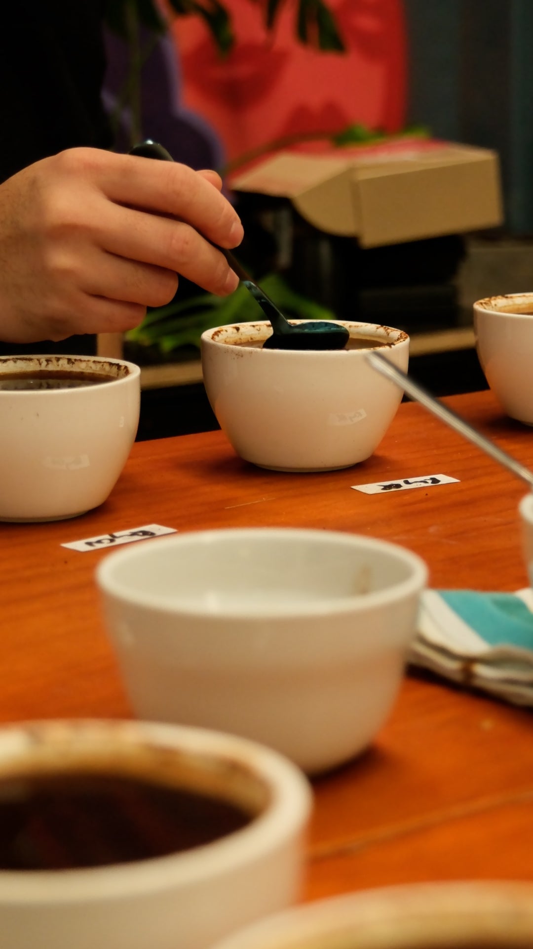 Ceramic cups on a wooden table, specialty coffee cupping as a part of the sensory barista course 