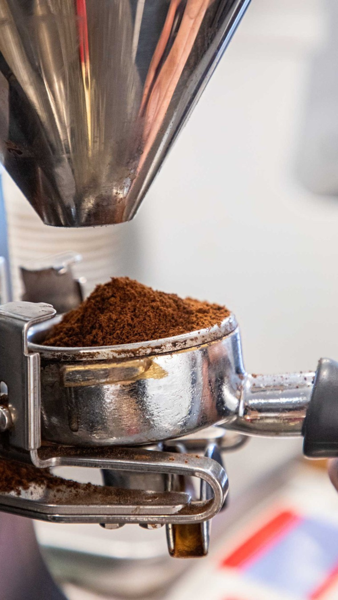 Close-up of a coffee grinder with ground coffee