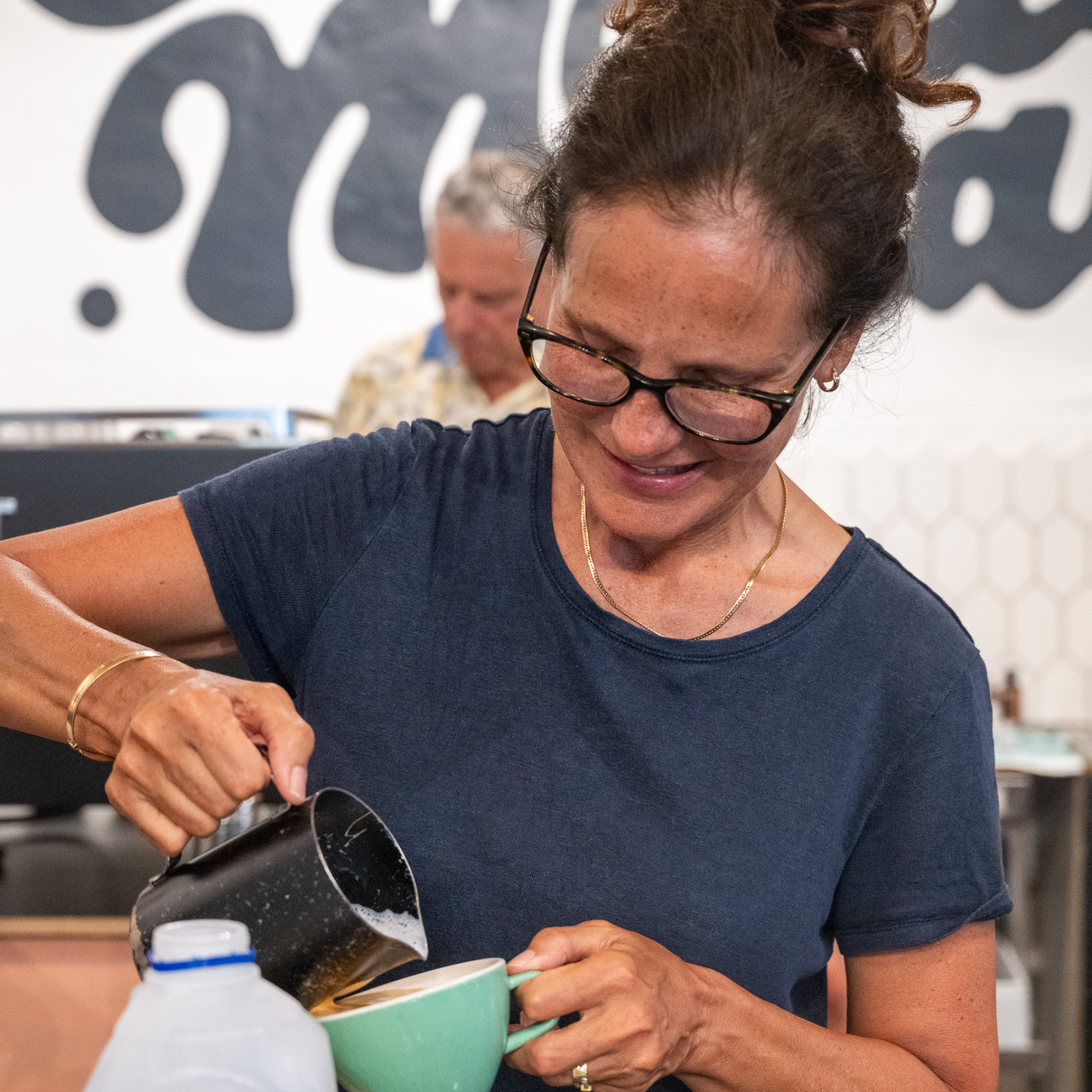 Barista course participant pouring latte art in coffee cup
