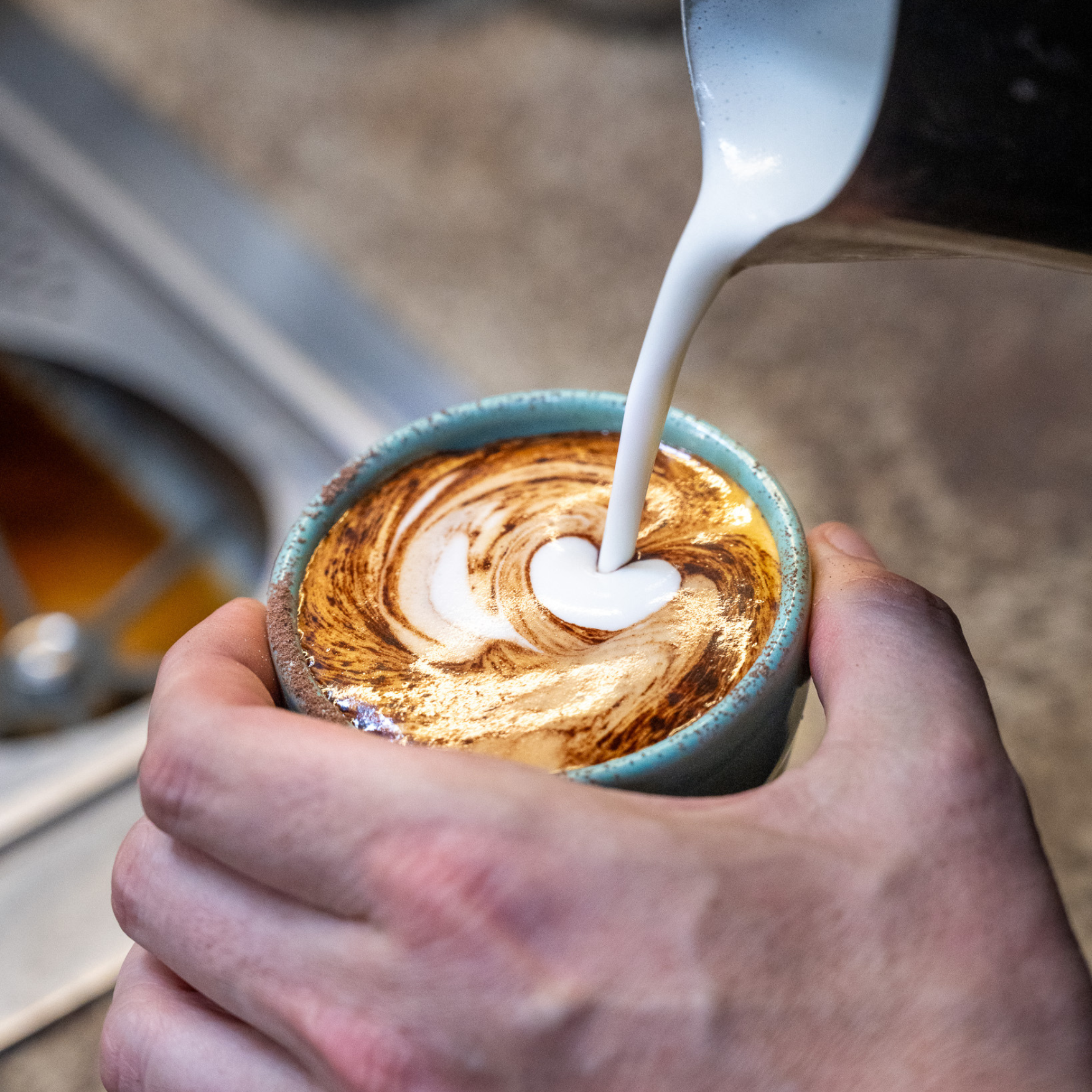 Student pouring latte art heart pattern at Black Market Training barista course Sydney