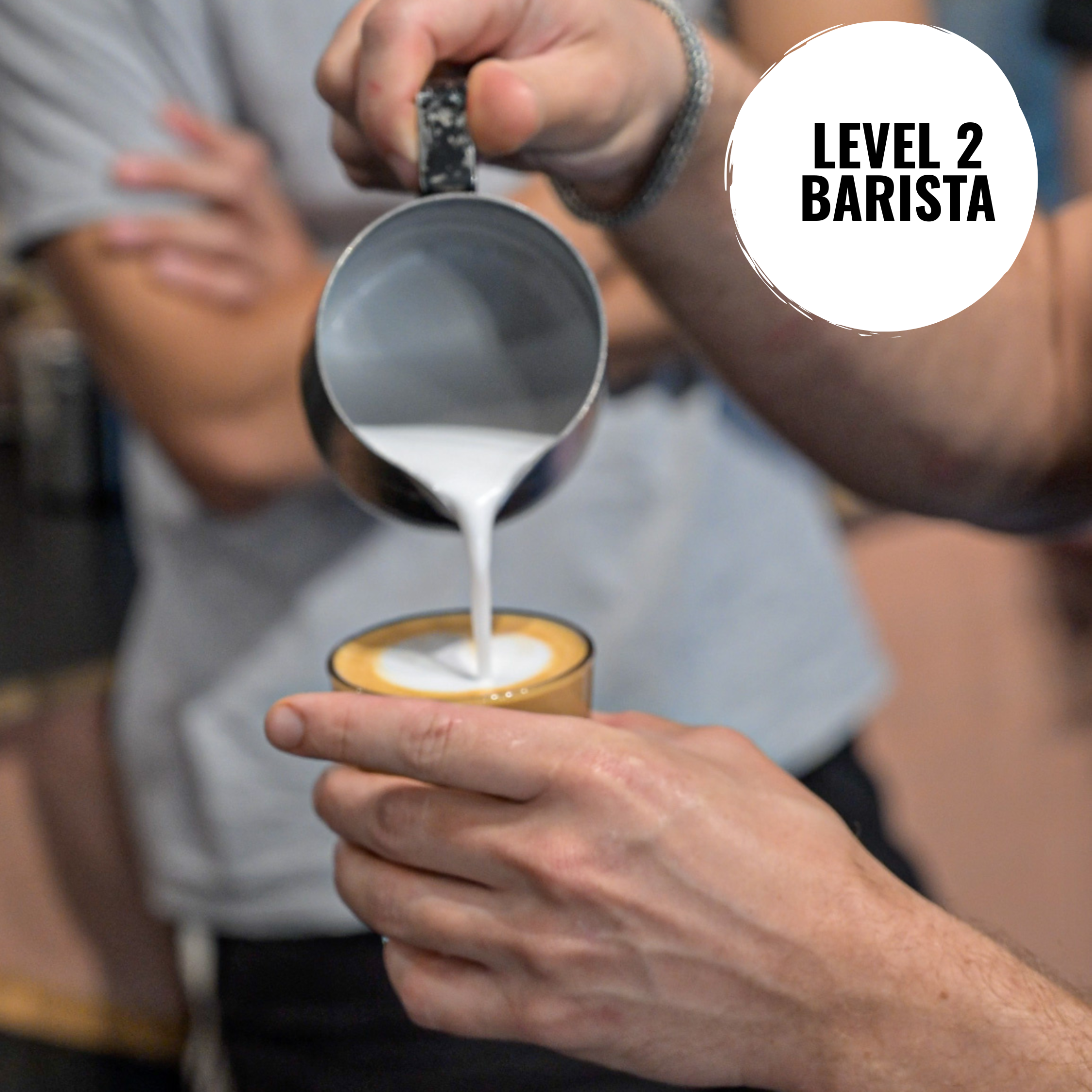 Barista pouring milk into a coffee cup 